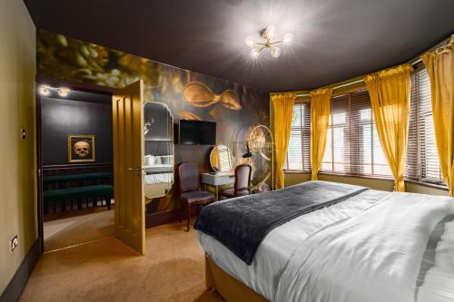 a bedroom with a bed and a table and a desk at City Retreat, Spacious 4 Bed House, Games Room, Parking, Hot Tub & BBQ in Cardiff