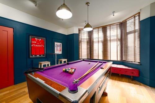 a pool table in a room with blue walls at City Retreat, Spacious 4 Bed House, Games Room, Parking, Hot Tub & BBQ in Cardiff