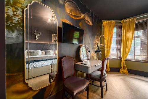 a bedroom with a bed and a desk and a mirror at City Retreat, Spacious 4 Bed House, Games Room, Parking, Hot Tub & BBQ in Cardiff