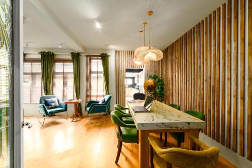 a living room with a table and green chairs at City Retreat, Spacious 4 Bed House, Games Room, Parking, Hot Tub & BBQ in Cardiff
