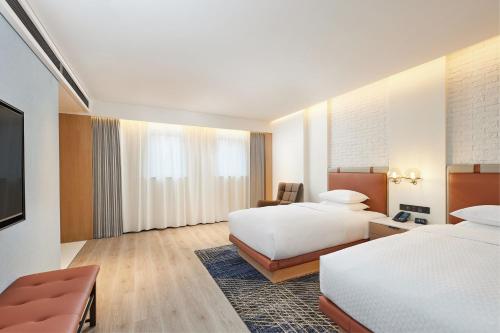 um quarto de hotel com duas camas e uma televisão em Four Points by Sheraton Changsha, Tianxin em Changsha