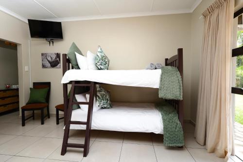 two bunk beds in a room with a window at Hhusha Hhusha in Malelane