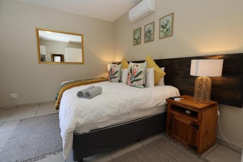 a bedroom with a bed with a mirror and a lamp at Hhusha Hhusha in Malelane