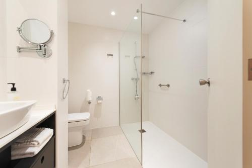 a bathroom with a shower and a toilet and a sink at Hotel Vista Park in Can Picafort