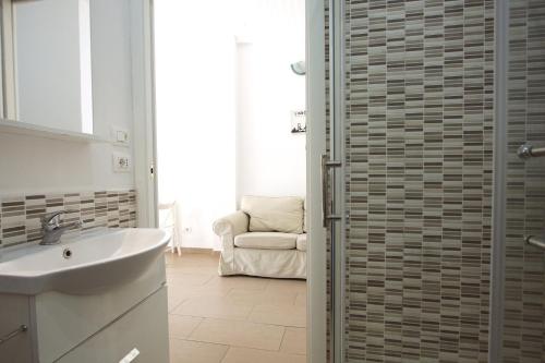 a bathroom with a sink and a shower with a mirror at Simona Beach Holiday House in Anzio