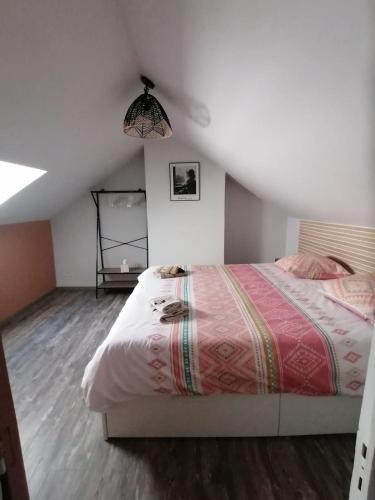 une chambre avec un grand lit dans un grenier dans l'établissement MA SOLOGNE,ZOO BEAUVAL,CHATEAUX DE LA LOIRE,GOLF, à Sassay