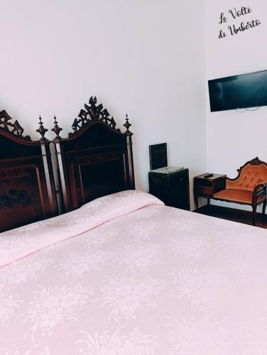 a bedroom with a large bed with a wooden headboard at Le volte di Umberto in Sogliano Cavour
