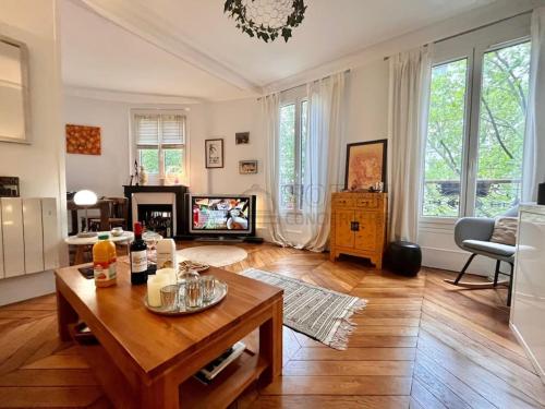 un salon avec une table et une télévision dans l'établissement Le Montmartre Paris 18, à Paris