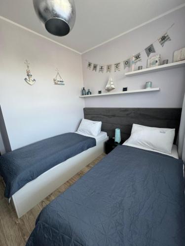 ヤストシェンビャ・グラにあるNord House Apartamentのベッド2台(サイドサイドサイド)が備わる小さな部屋のベッド2台