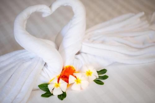 Dos cisnes blancos formando un corazón sobre un pastel en NaLinNaa Resort Buriram ณลิ์ณน่า รีสอร์ท บุรีรัมย์ en Buriram
