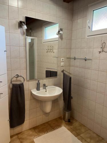 a bathroom with a sink and a mirror at R-Home Apartman in Zamárdi
