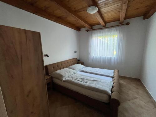a small bedroom with a bed and a window at R-Home Apartman in Zamárdi