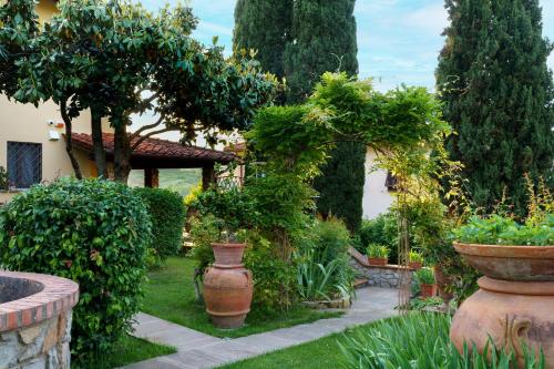 un giardino con due grandi vasi e alberi di Villa Desideria a Figline Valdarno