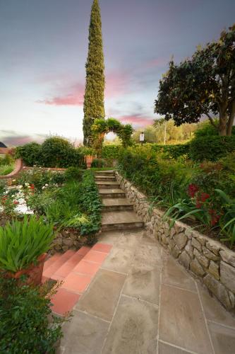 a garden with a stone path and a tree at Villa Desideria in Figline Valdarno