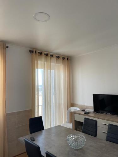 a dining room with a table with chairs and a television at Casa Miradouro in Nazaré