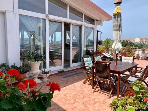 a patio with a wooden table and chairs at Dreaming Penthouse in Vieste