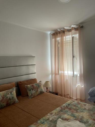 a bedroom with two beds and a window at Casa Miradouro in Nazaré