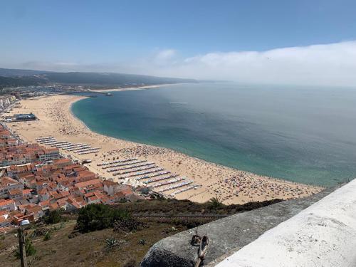 a view of a beach with umbrellas and the ocean at Casa Miradouro in Nazaré