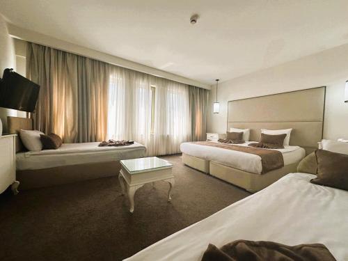イスタンブールにあるTaximtown Hotelのベッド2台とテーブルが備わるホテルルームです。