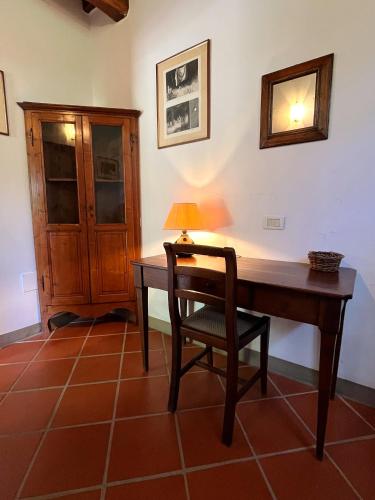 a desk with a lamp and a chair in a room at Podere Sole in Trequanda