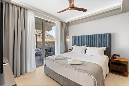 a bedroom with a bed and a ceiling fan at Ennea Muses Rooms and Suites in Nafplio