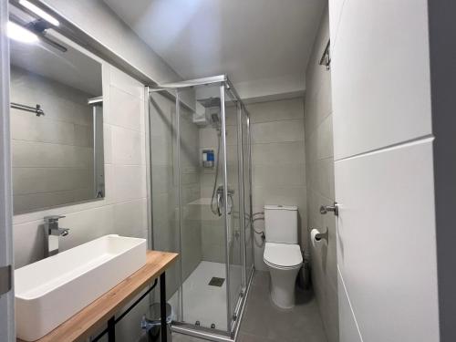 uma casa de banho com um chuveiro, um lavatório e um WC. em Hostal Mindanao em Salamanca