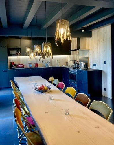 une grande cuisine avec une grande table et des chaises dans l'établissement Châlet du gîte des enfants sauvages, à Vacheresse