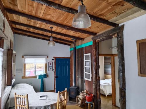 Habitación con 2 camas y puerta azul en Cabañas Juan Jose, en Piruquina