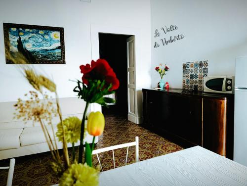 a living room with a table with flowers on it at Le volte di Umberto in Sogliano Cavour