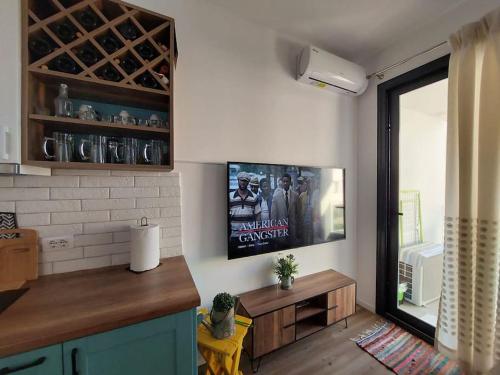 a kitchen with a flat screen tv on a wall at Condo "Comfort" in Vlorë