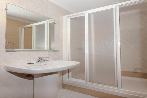uma casa de banho com um lavatório e um chuveiro em Apartamentos el Acebo em Naves