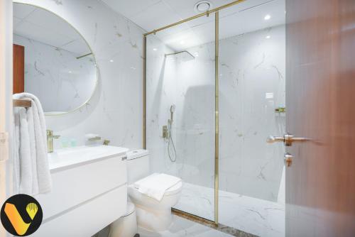 a bathroom with a shower and a toilet and a sink at Vogue - The Greens and Views in Dubai