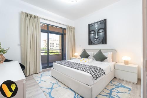 a bedroom with a large bed and a large window at Vogue - The Greens and Views in Dubai