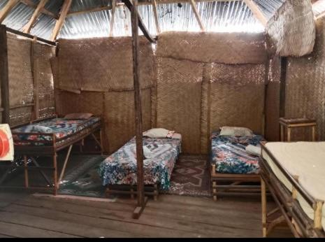 a room with two beds and two tables in it at Chez Bethy Jungle et Océan in Abene