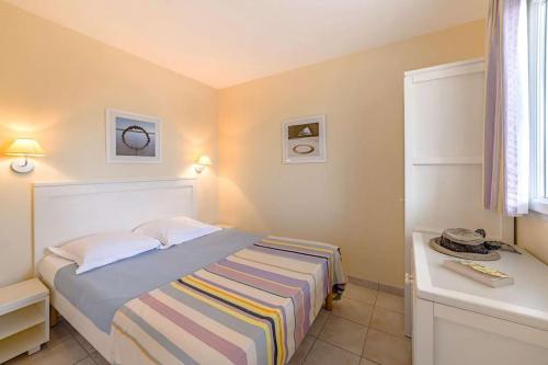 une petite chambre avec un lit et un bureau dans l'établissement L'Estran - Appt Confortable avec Piscine Chauffée, à Saint-Jean-dʼOrbetiers