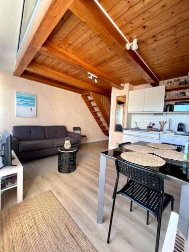 une cuisine et un salon avec une table et un canapé dans l'établissement Magnifique duplex vue océan au cœur de la station, à Carnac