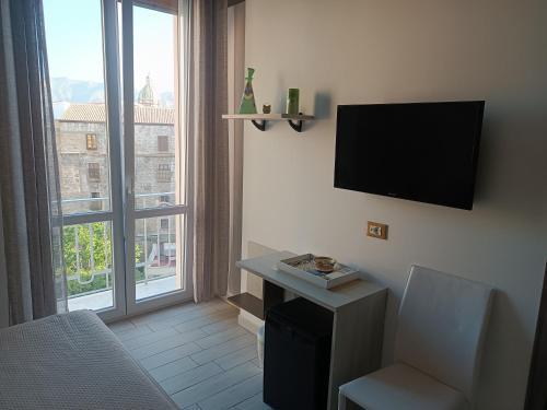 a room with a tv and a chair and a window at Le Cupole Decò in Palermo
