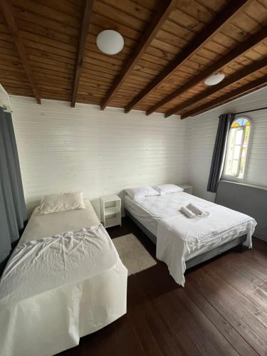 a bedroom with two beds and a wooden ceiling at Casa c/ bela vista para Baía Sul in Florianópolis