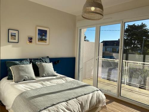 une chambre avec un lit et un balcon dans l'établissement Vue Mer 2 pas des plages 10 pers 4 chambres Villa KER LOT PLAGE, à Saint-Nazaire