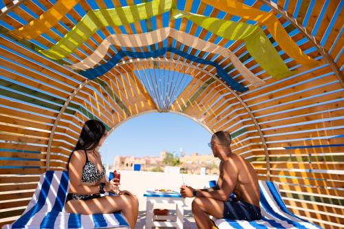 a man and a woman sitting on chairs in a tent at Akassia Swiss Resort in Quseir