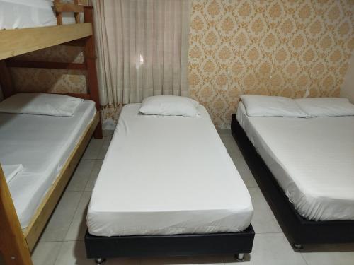 Hotel Kasvel في فاليدوبار: سريرين في غرفة نوم مع ثلاث سرائر متدهورة