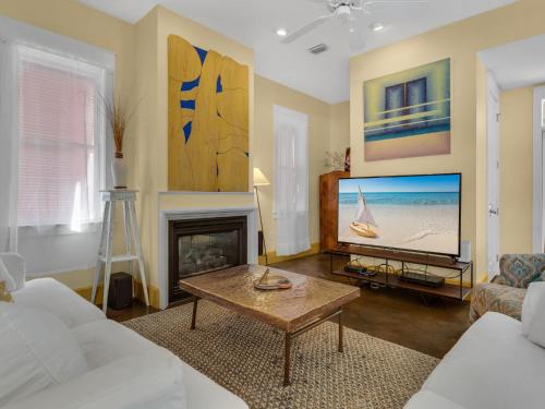 a living room with a tv and a fireplace at Soleil Levant by Newman-Dailey in Destin