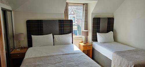 una camera d'albergo con due letti e una finestra di Armadale Guest House a Inverness