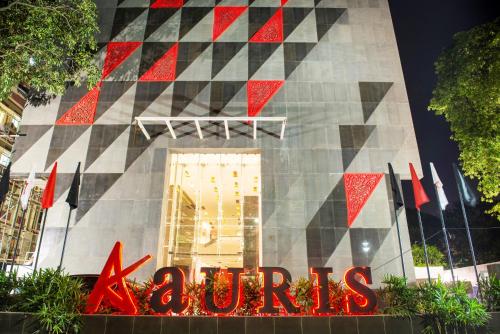 un edificio con una señal roja delante de él en Aauris en Calcuta