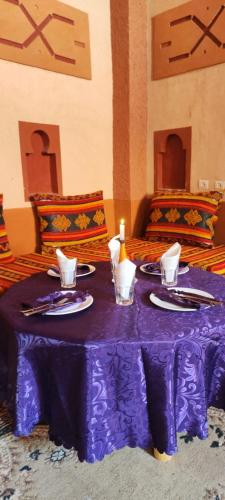 a purple table with plates and a bottle on it at Gorges View Dades in Tamellalt