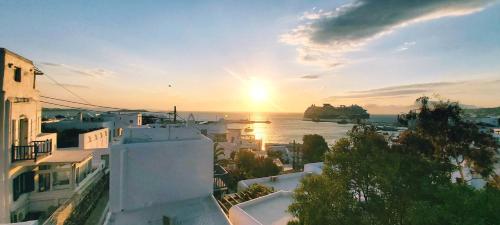 Blick auf den Sonnenuntergang über dem Wasser mit Gebäuden in der Unterkunft Merriam mykonos town in Mykonos Stadt