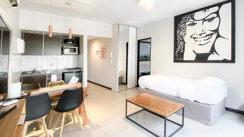 uma cozinha e sala de estar com uma cama e uma mesa em Feel Buenos Aires Apartments em Buenos Aires