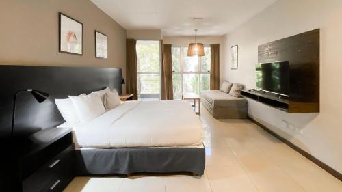 um quarto com uma cama grande e uma televisão de ecrã plano em Feel Buenos Aires Apartments em Buenos Aires