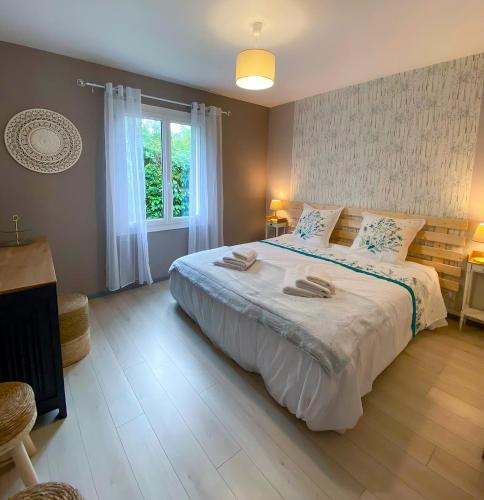 une chambre avec un grand lit et une fenêtre dans l'établissement Grand Gîte CLIMATISE Ma Maison de Vacances proche de La Rochelle 10 personnes, à Saint-Médard-dʼAunis