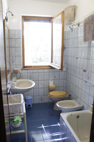 a bathroom with two sinks and a toilet and a window at LA TANA DI TONY in Viterbo